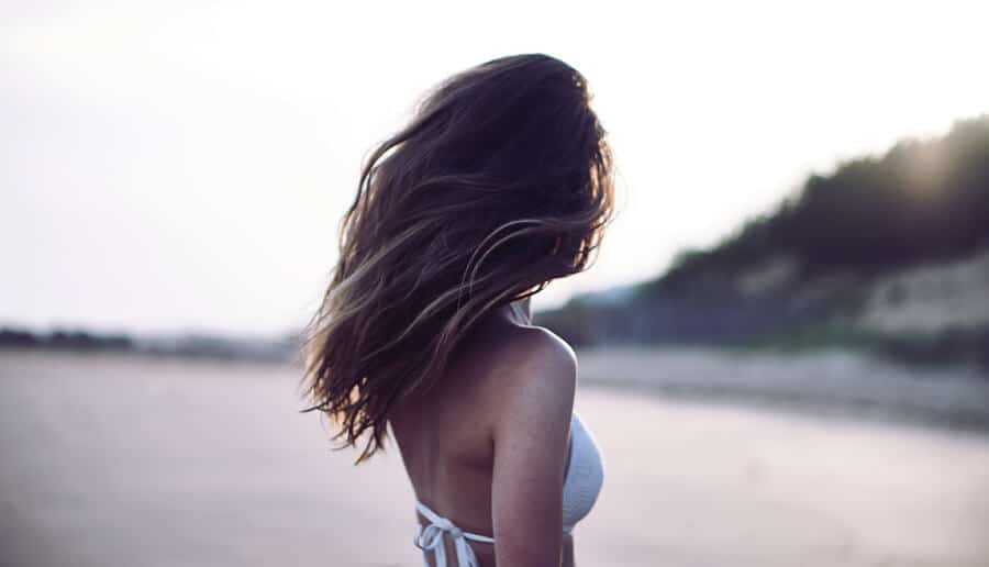 mulher com os cabelos ao vento na praia