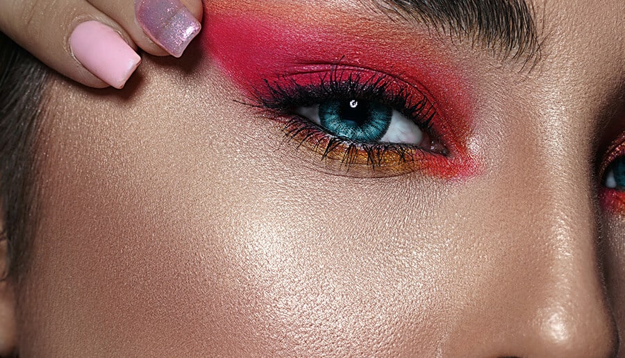 detalhe do olho de uma make colorida com tons de rosa coral e amarelo.