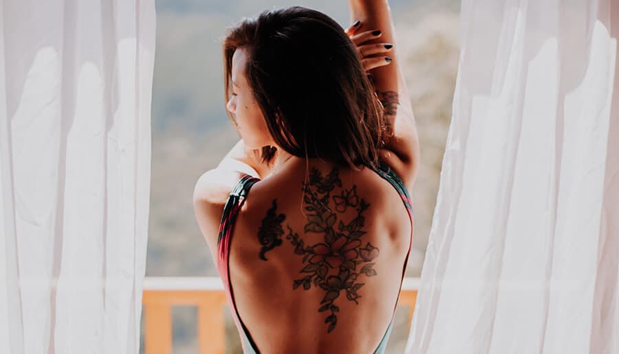 Mulher com tatuagem nas costas.