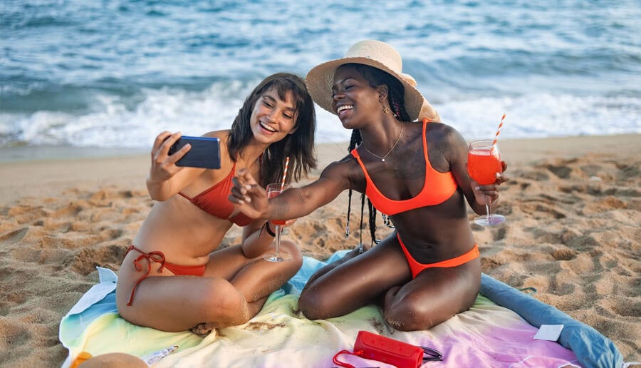 Mulher na praia tirando foto.